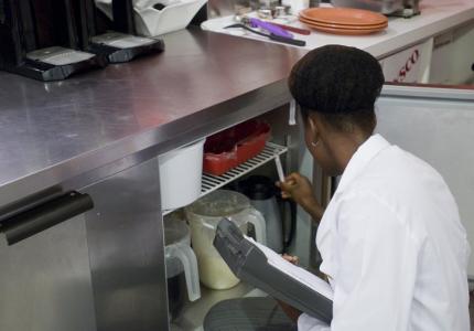 Inspecting temperature of restaurant refrigerator